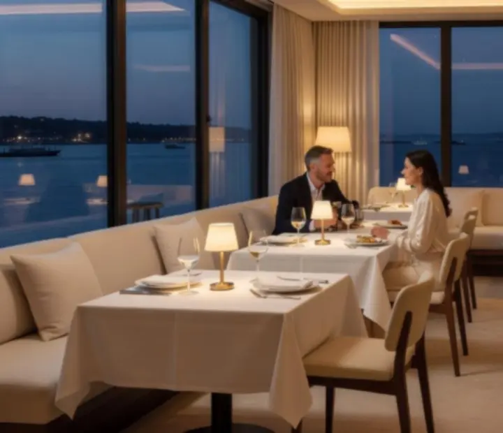 Panoramic view of Harbour & Deck's coastal-modern dining room with warm evening lighting
